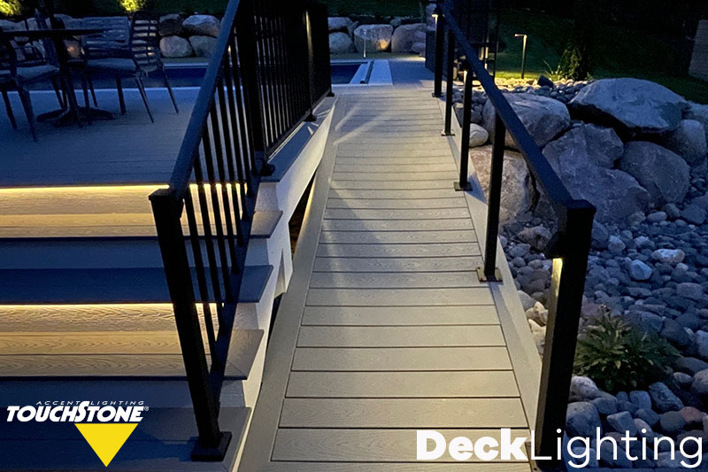 A deck is enhanced with garden lights, creating an illuminated walkway that showcases commercial lighting.
