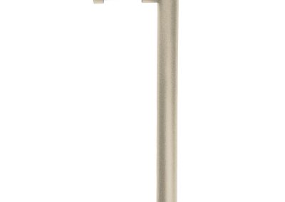 The Tubelle is a beige, L-shaped outdoor light fixture with a horizontal top housing a recessed light and a vertical pole for mounting.